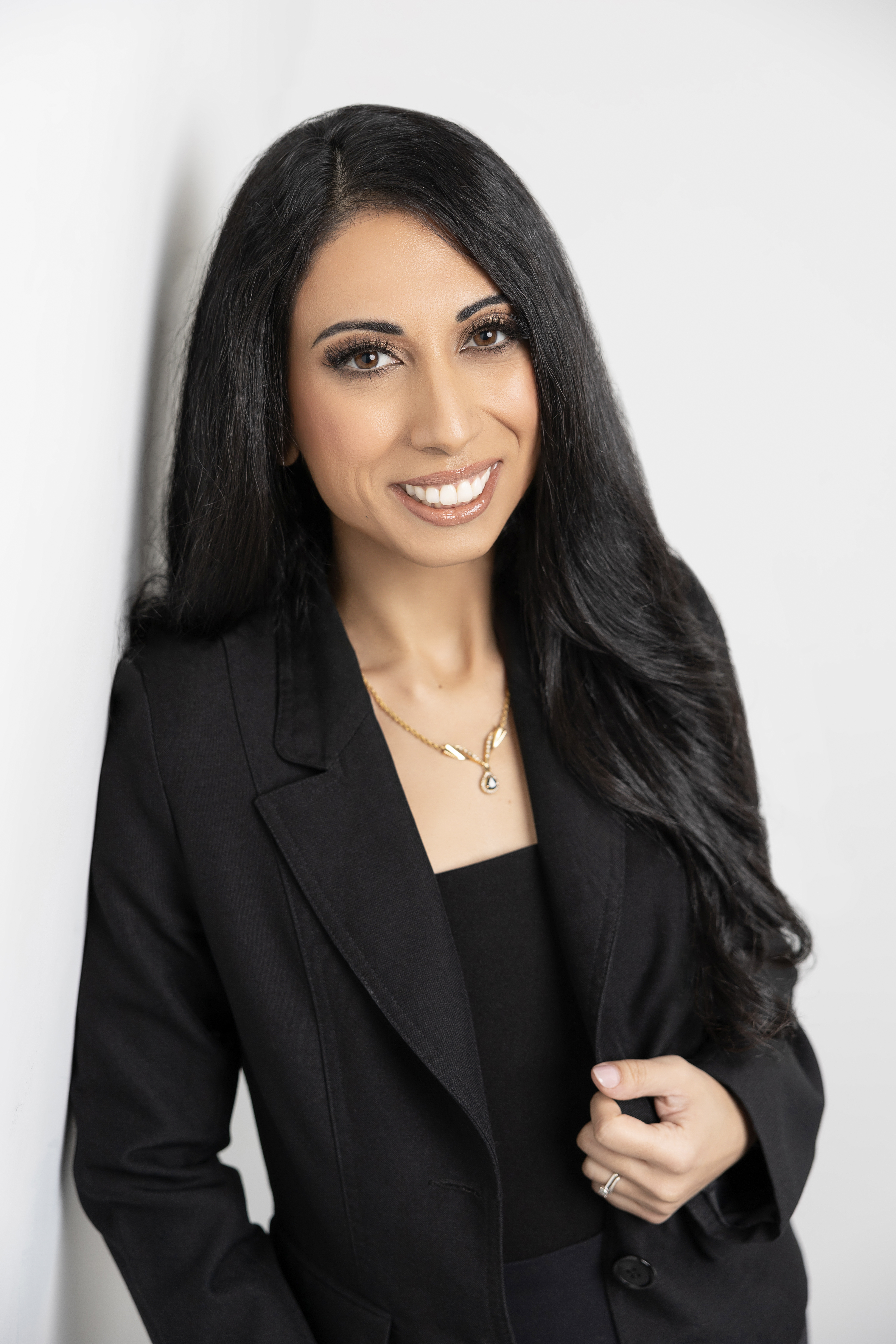 Author Rebecca Zorg smiling in a black blazer against a white backdrop
